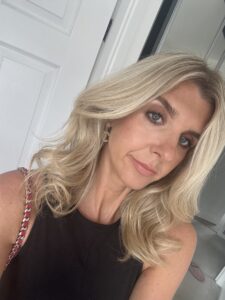 A woman with blonde hair wearing a black top