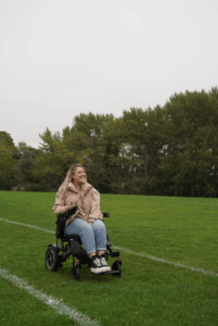 A woman in a wheelchair on a grasy area