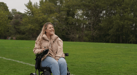 A woman in a wheelchair on a grasy area