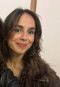 A woman with long dark hair smiling at camera