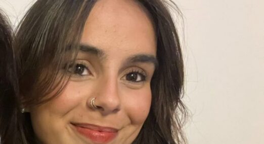 A woman with long dark hair smiling at camera