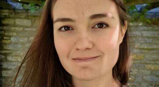 A young woman with dark hair is smiling at the camera.