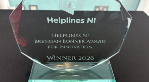 An eight sided glass award on a stand.